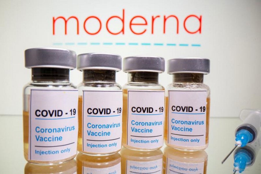 Vials with a sticker reading, "COVID-19 / Coronavirus vaccine / Injection only" and a medical syringe are seen in front of a displayed Moderna logo in this illustration taken on October 31, 2020 — Reuters/Files