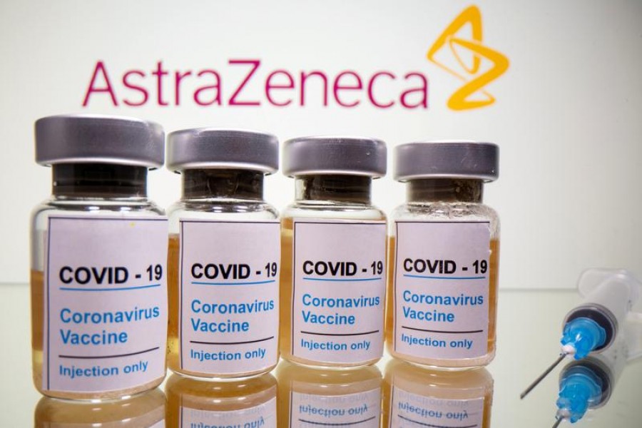 Vials with a sticker reading, "COVID-19 / Coronavirus vaccine / Injection only" and a medical syringe are seen in front of a displayed AstraZeneca logo in this illustration taken October 31, 2020. REUTERS/Dado Ruvic