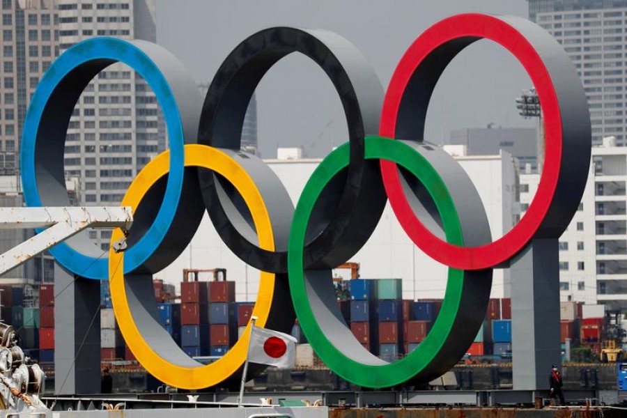 The giant Olympic rings are seen behind Japan's national flag amid the coronavirus disease (COVID-19) outbreak, at the waterfront area at Odaiba Marine Park in Tokyo, Japan August 6, 2020. REUTERS/Kim Kyung-Hoon/File Photo