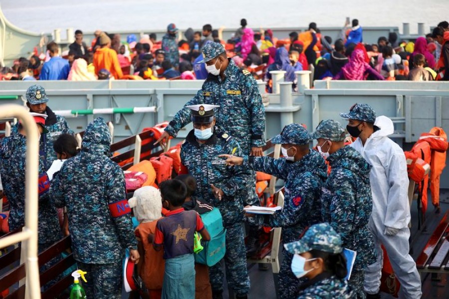 Bangladesh navy personnel check Rohingyas before they board a ship to move to Bhasan Char island in Chattogram, Bangladesh, December 29, 2020. REUTERS/Mohammad Ponir Hossain