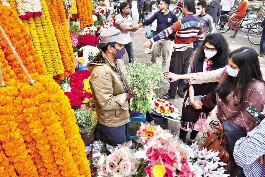 Every occasion like the New Year drives up the demand for flowers but the pandemic has made it different this year as is evident from this photo showing a handful of customers buying flowers from a shop at Shahbagh in the city on Thursday, the last day of 2020 —FE photo by Shafiqul Alam