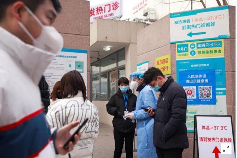 FILE PHOTO: A medical staff member in PPE gives advice outside a nucleic testing site at a hospital, in Beijing, China December 28, 2020. REUTERS/Thomas Peter