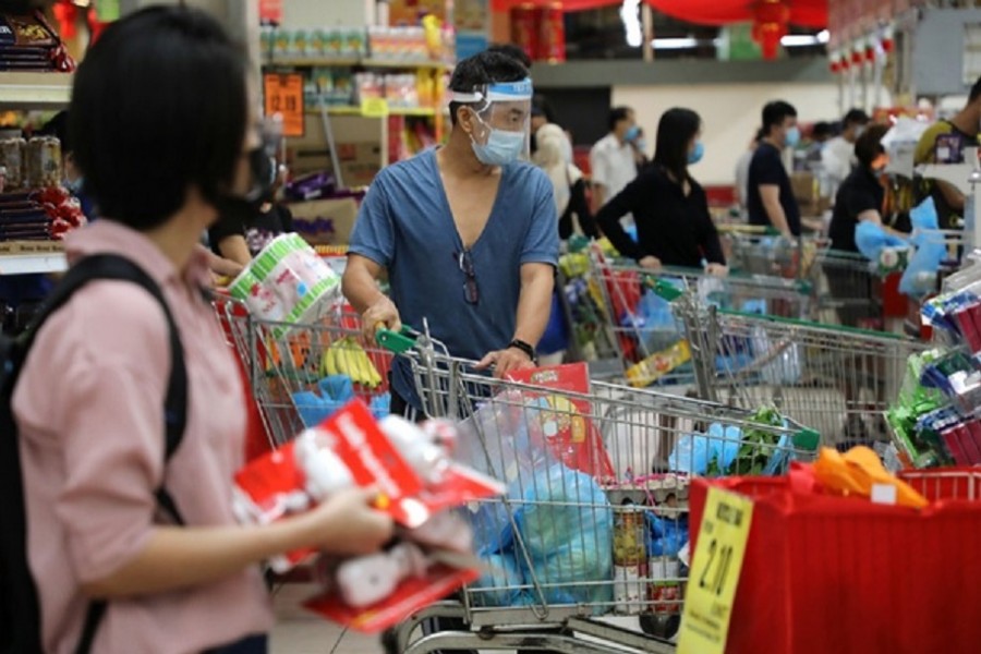 People line up to pay at a supermarket, amid the coronavirus disease (COVID-19) outbreak in Kuala Lumpur, Malaysia January 12, 2021. Reuters