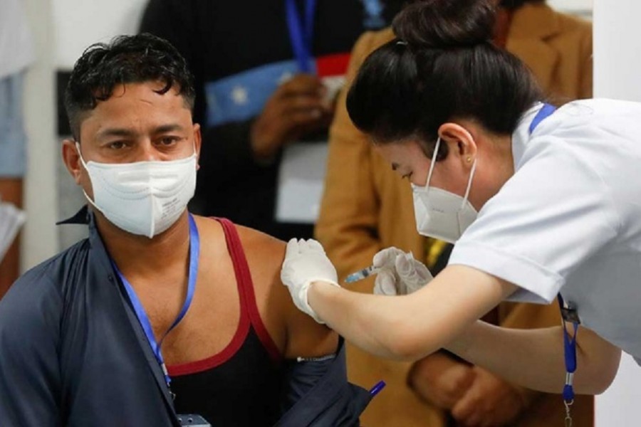 Sanitation worker Manish Kumar, who according to the officials is the first person in the country vaccinated against the COVID-19, receives a dose of Bharat Biotech's COVAXIN during the coronavirus disease (COVID-19) vaccination campaign at All India Institute of Medical Sciences (AIIMS) hospital in New Delhi, India, January 16, 2021. REUTERS/Adnan Abidi