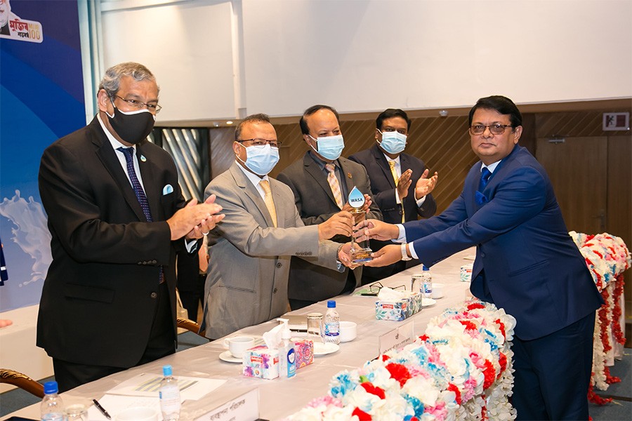 Local Government, Rural Development and Cooperatives Minister Md Tazul Islam handing over a crest to Managing Director and also CEO of Premier Bank Limited M Reazul Karim, FCMA, in the city on Monday