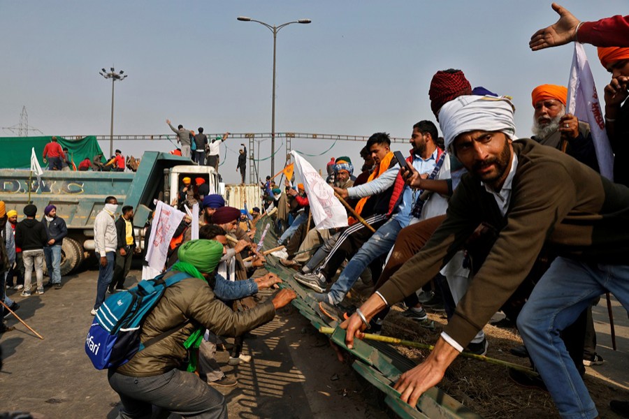 Farmers try to remove a barricade during a tractor rally to protest against farm laws on the occasion of India's Republic Day in Delhi, India on January 26, 2021 — Reuters photo