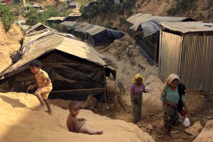 ARCHIVE PHOTO: Women carry water jugs up a landslide-prone hill in the Balukhali camp for Rohingya refugees in southern Bangladesh, February 13, 2018. REUTERS/Andrew RC Marshall