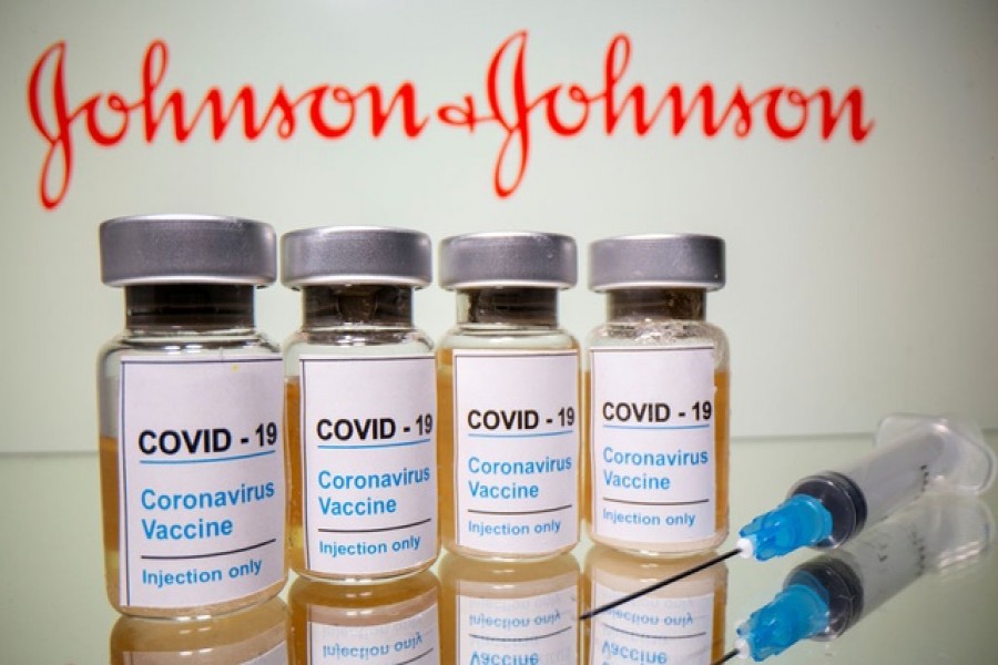 Vials with a sticker reading, "COVID-19 / Coronavirus vaccine / Injection only" and a medical syringe are seen in front of a displayed Johnson & Johnson logo in this illustration taken October 31, 2020. Reuters