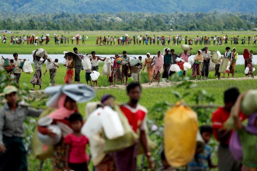 Rohingya refugees, who crossed the border from Myanmar two days before, walk after they received permission from the Bangladeshi army to continue on to the refugee camps, in Palang Khali, near Cox's Bazar, Bangladesh October 19, 2017 — Reuters/Files