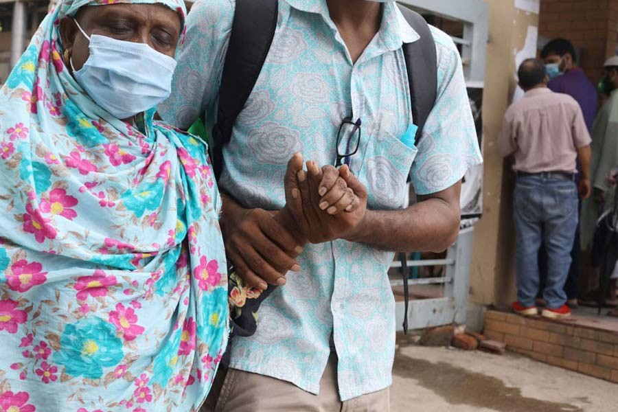 A woman with the support of her son leaving a hospital in Dhaka after giving sample for Covid-19 test       - FE file photo