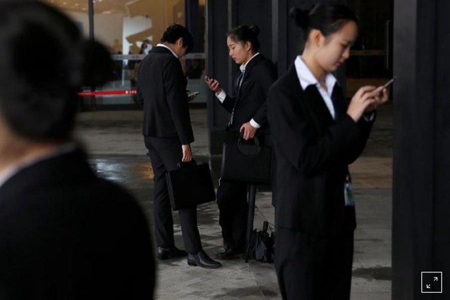 FILE PHOTO: People check their phones during the third annual World Internet Conference in Wuzhen town of Jiaxing, Zhejiang province, China November 17, 2016. REUTERS/Aly Song