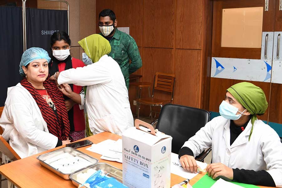 A health worker at Sheikh Hasina Burn and Plastic Surgery Institute in Dhaka receives first dose of COVID-19 vaccine on Monday -PID Photo