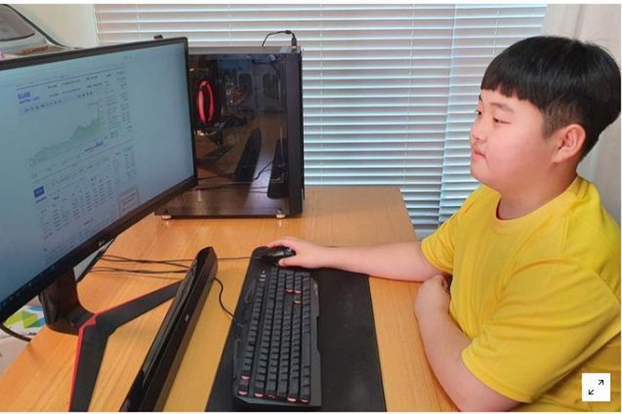 Kwon Joon looks at a monitor as he checks investing information at his room in Jeju, South Korea, February 8, 2021. Lee Eun-joo/Handout via REUTERS