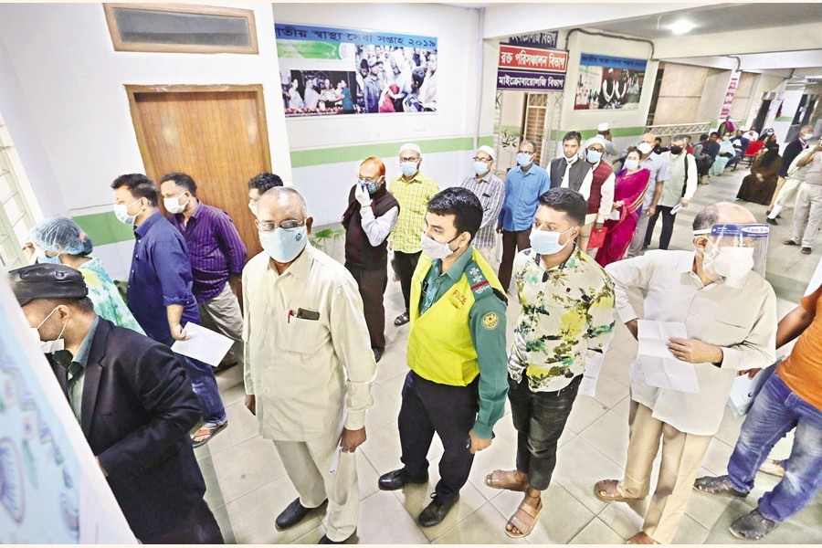 People wait in long queues to register for Covid-19 vaccination at Mugda Medical College and Hospital in the capital on Tuesday— FE photo by KAZ Sumon