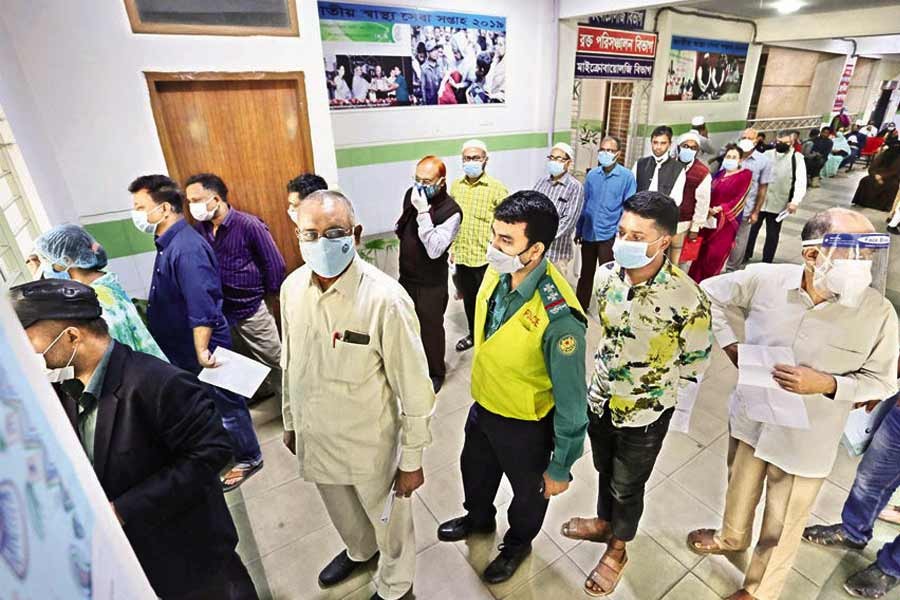 People wait in long queues to register for Covid-19 vaccination at Mugda Medical College and Hospital in the capital on Tuesday —FE photo by KAZ Sumon