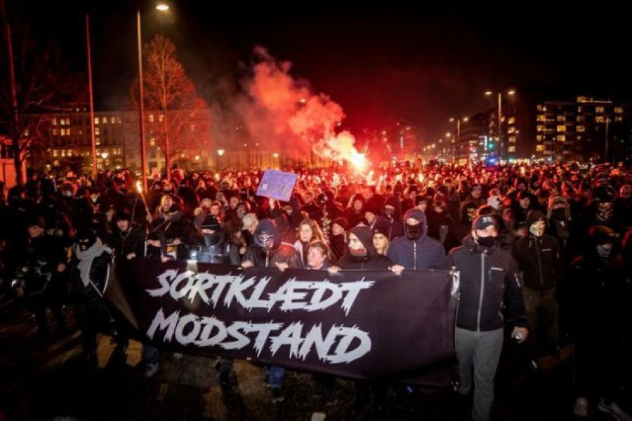 Demonstrators hold a banner reading "Black-clad resistance" during a protest by a group called Men in Black against Covid-19 restrictions in Copenhagen, Denmark on January 23, 2021  — Mads Claus Rasmussen via REUTERS