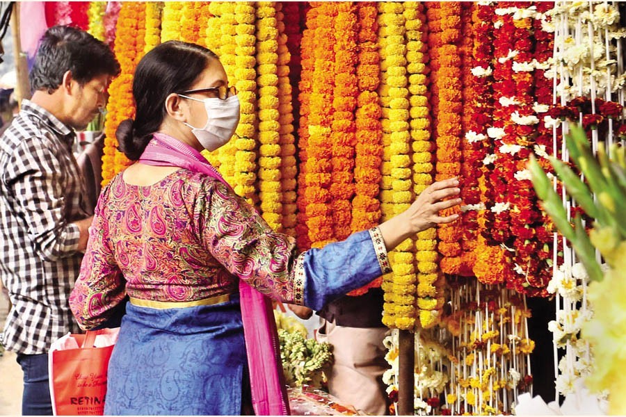 A woman carefully making her choice at a flower shop in Shahbagh flower market of the capital on Friday. The biggest flower hub of Dhaka traditionally sees a brisk business during Pohela Falgun, a festival welcoming the advent of spring, and the Valentine's Day - both to be celebrated on Sunday (tomorrow) — FE Photo by KAZ Sumon