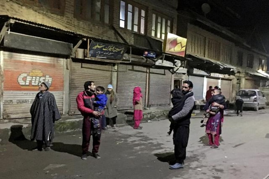 Residents carrying their children stand on a road after vacating their houses following an earthquake in Srinagar on February 12, 2021 — Reuters photo