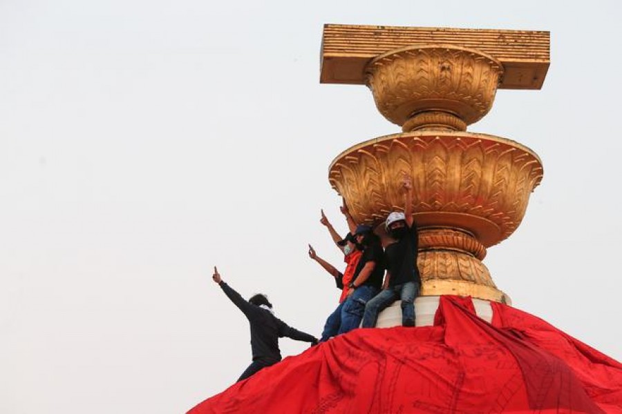 Protesters show the three finger salute atop the Democracy Monument as pro-democracy demonstrators protest to demand the release of their leaders in Bangkok, Thailand, February 13, 2021. REUTERS/Soe Zeya Tun