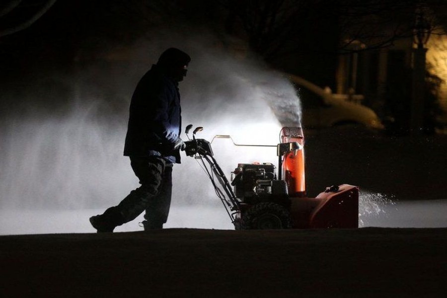 Roger Hake gets an assist from his truck lights as he clears snow from his driveway before the sun comes up in Webster, near Rochester, New York, US on February 16, 2021 — USA Today Network via REUTERS