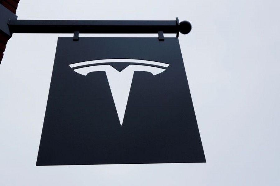 A Tesla logo hangs on a building outside of a Tesla dealership in New York, US on April 29, 2016 — Reuters/Files