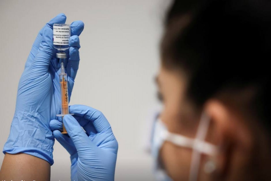 A health worker prepares an injection with a dose of Astra Zeneca coronavirus vaccine, at a vaccination centre in Westfield Stratford City shopping centre, amid the outbreak of coronavirus disease (COVID-19), in London, Britain, February 18, 2021. REUTERS/Henry Nicholls/File Photo