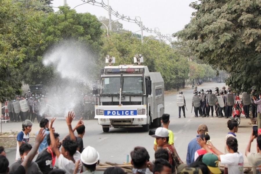 Police officers stand in front of people who protest against the military coup, in Mandalay, Myanmar, February 20, 2021. REUTERS/Stringer