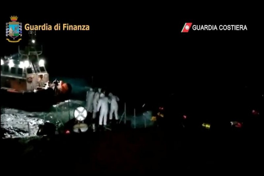 Members of the Italian Coast Guard throw buoyancy aid during a rescue operation after a boat carrying migrants capsized off the coast of Lampedusa, Italy, February 20, 2021 in this still image taken from video. Guardia Costiera/Handout via REUTERS