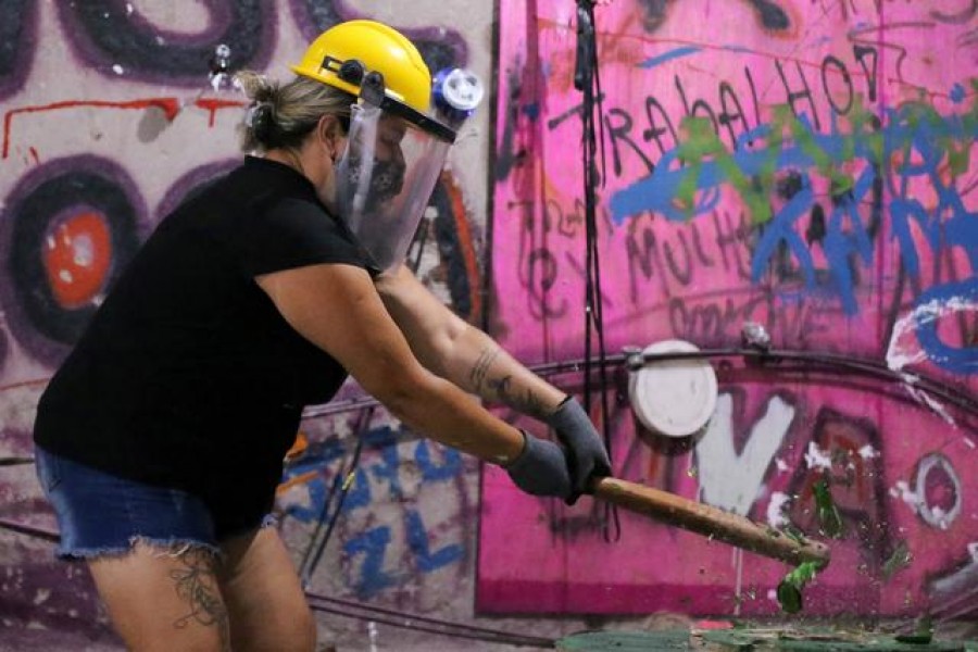 Luciana Holanda smashes a bottle at the Rage Room, a place where people can destroy objects to vent their anger, in Sao Paulo, Brazil, February 19, 2021. REUTERS/Carla Carniel