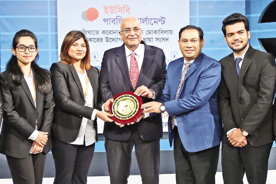 The winning team receives a crest from economist Dr Debapriya Bhattacharya and Chairman of the Debate for Democracy Hasan Ahmed Chowdhury Kiron at a mock parliamentary debate organised by the Debate for Democracy in the city on Monday.