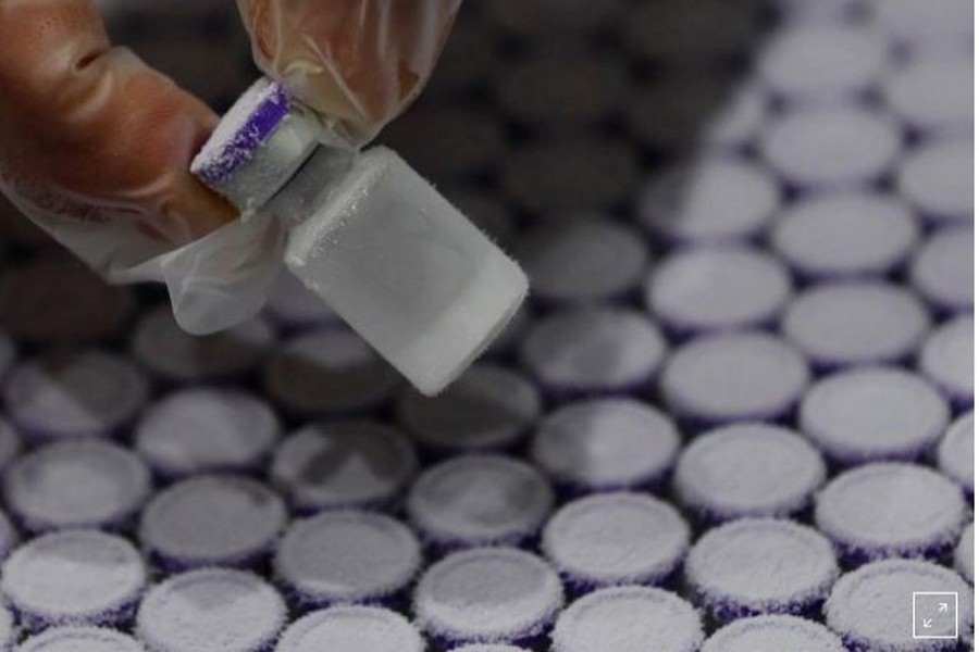 FILE PHOTO: A staff member takes out a vial containing water from a pharmaceutical refrigerator during a mock inoculation exercise, as Japan prepares for coronavirus disease (COVID-19) vaccination campaign, at a college gym in Kawasaki, Japan, January 27, 2021. REUTERS/Kim Kyung-Hoon