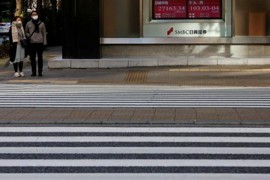 A man and woman wearing facial masks, following the coronavirus disease (Covid-19) outbreak, stand next to an electric board showing exchange rate between Japanese Yen and US dollar (L) and Nikkei index outside a brokerage at a business district in Tokyo, Japan, January 4, 2021 — Reuters/Files