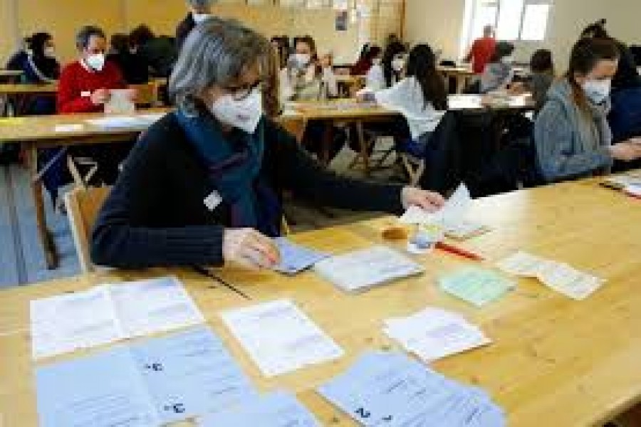 A member of the district election office Stadtkreis 3, wearing a protective mask, counts ballots on the day of a Swiss referendum on banning burqas and other facial coverings, in Zurich, Switzerland, March 7, 2021 — Reuters