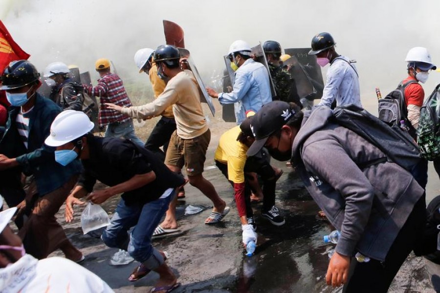 Tear gas and fire extinguisher gas float around demonstrators during a protest against the military coup in Naypyitaw, Myanmar, March 8, 2021. REUTERS/Stringer