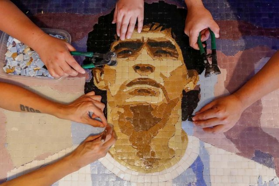 FILE PHOTO: Gabriela Pereyra, Paula Soto, ad Gonzalo Lopez Lluch, members of the cultural organisation Comando Maradona, prepare a mosaic as a homage to late Argentine soccer superstar Diego Armado Maradona, at their workshop, in Buenos Aires, Argentina February 24, 2021. Picture taken February 24, 2021. REUTERS/Agustin Marcarian