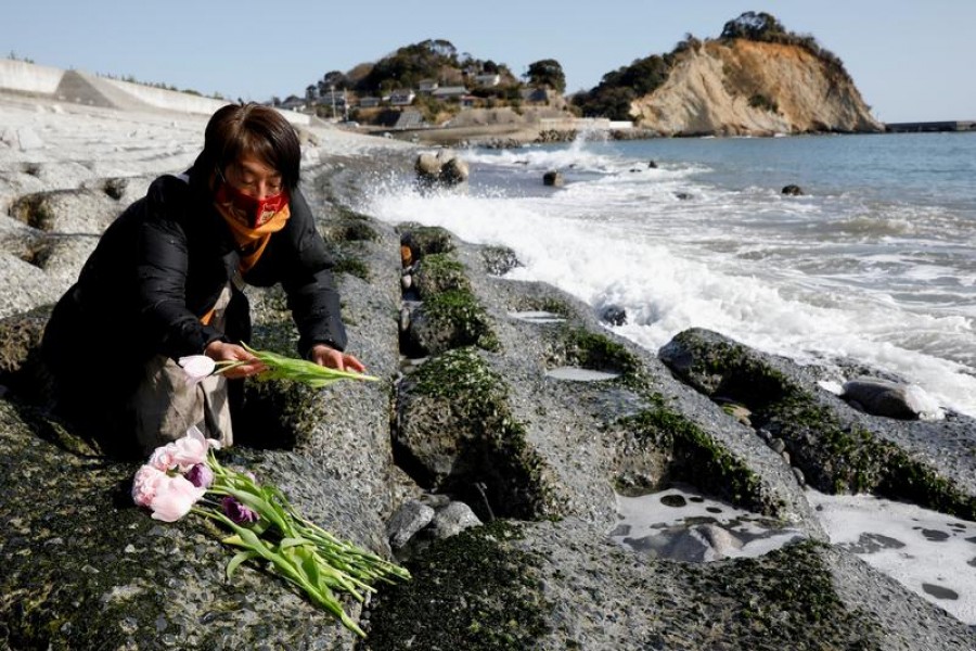 Mariko Odawara places flowers to mourn the victims of the earthquake and tsunami that killed thousands and triggered the worst nuclear accident since Chernobyl, during its 10th anniversary, in Iwaki, Fukushima prefecture, Japan, March 11, 2021 — Reuters/Files