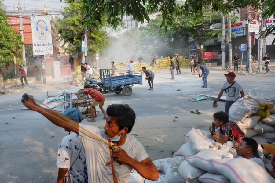 A man uses a slingshot during the security force crack down on anti-coup protesters in Mandalay, Myanmar March 14, 2021. REUTERS/Stringer