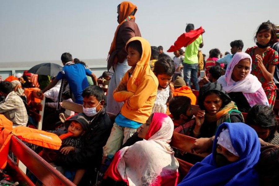 FILE PHOTO: Rohingya refugees sit on wooden benches of a navy vessel on their way to the Bhasan Char island in Noakhali district, Bangladesh, December 29, 2020. REUTERS/Mohammad Ponir Hossain/File Photo