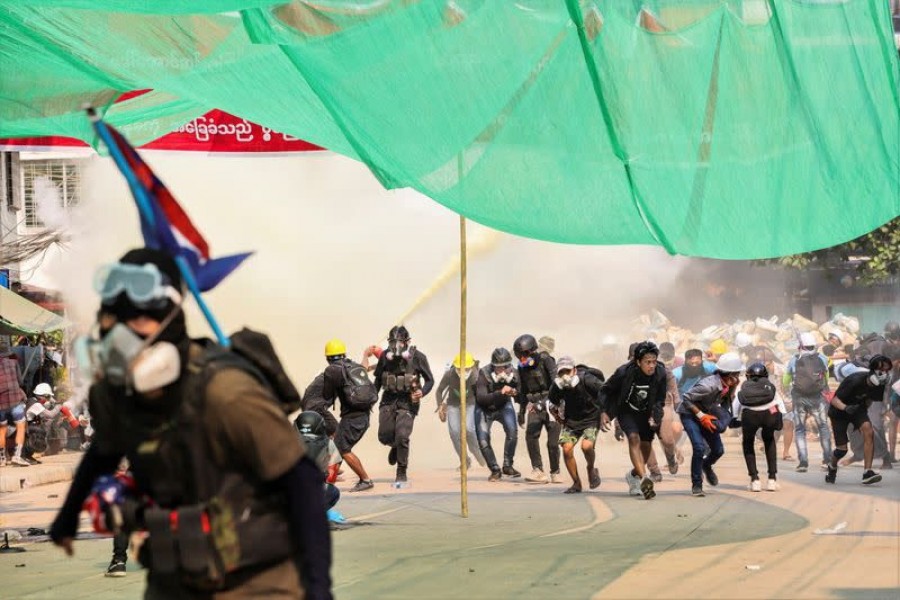 Protesters run during a crackdown of an anti-coup protests at Hlaing Township in Yangon, Myanmar on March 17, 2021 — Reuters/Stringer