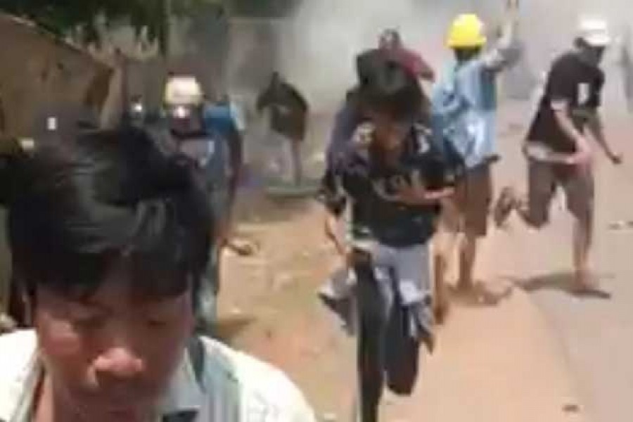 Protesters take cover during clashes with security forces in Monywa, Myanmar, March 21, 2021, in this still image from a video obtained by Reuters.