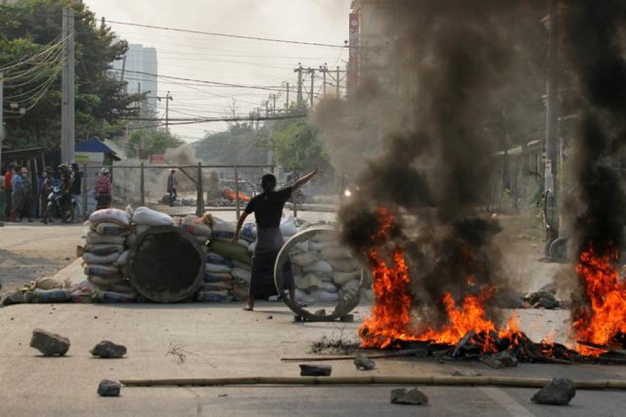 A demonstrator gestures near a barricade during a protest against the military coup in Mandalay, Myanmar March 22, 2021. REUTERS/Stringer