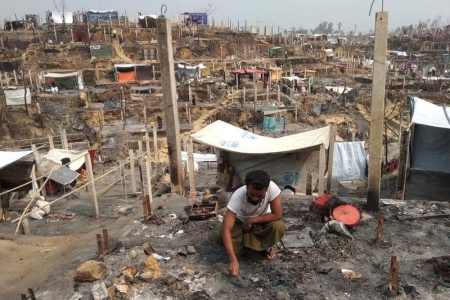 Mohammed Harun, 27, a Rohingya teacher who lost his parents in a deadly fire in Bangladesh camps, sifts through the charred remains of his hut in Cox's Bazar, Bangladesh on March 24, 2021 — Reuters photo