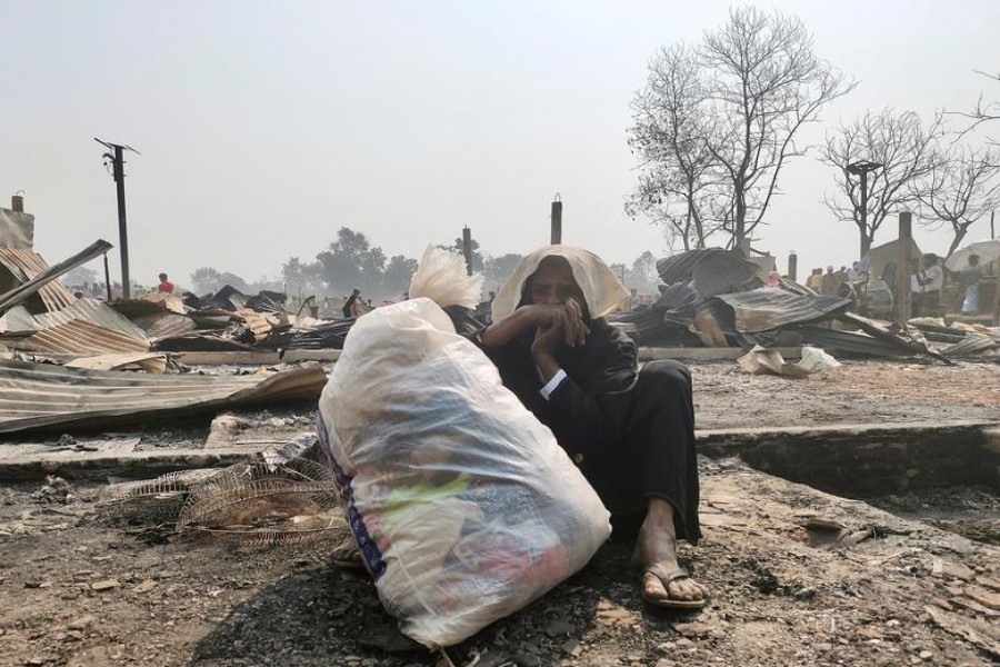 A Rohingya woman sits on the ground with her belongings after her shelter burned down in Cox's Bazar, Bangladesh on March 23, 2021 — Reuters photo