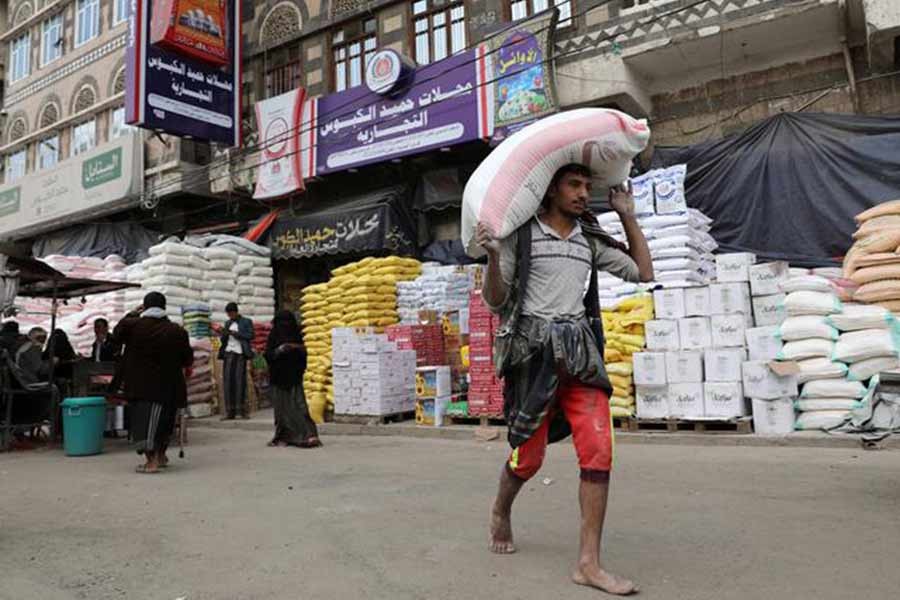 A worker carrying a sack of wheat flour outside a food store amid concerns over the spread of the COVID-19 in Sanaa of Yemen last year –Reuters file photo