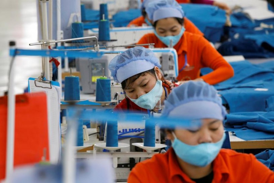 FILE PHOTO: Women work at Hung Viet garment export factory in Hung Yen province, Vietnam December 30, 2020. REUTERS/Kham