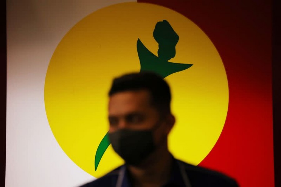 A man stands in front of a United Malays National Organization (UMNO) logo at its headquarters in Kuala Lumpur, Malaysia October 26, 2020 — Reuters