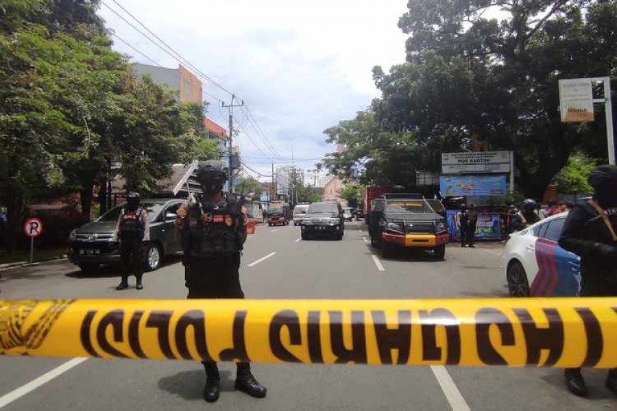 Armed police officers stand guard along a closed road following an explosion outside a Catholic church in Makassar, South Sulawesi province, Indonesia, March 28, 2021. REUTERS/Stringer