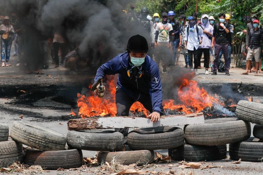 A man stands behind a barricade during a protest against the military coup, in Yangon, Myanmar March 27, 2021 — Reuters/Stringer