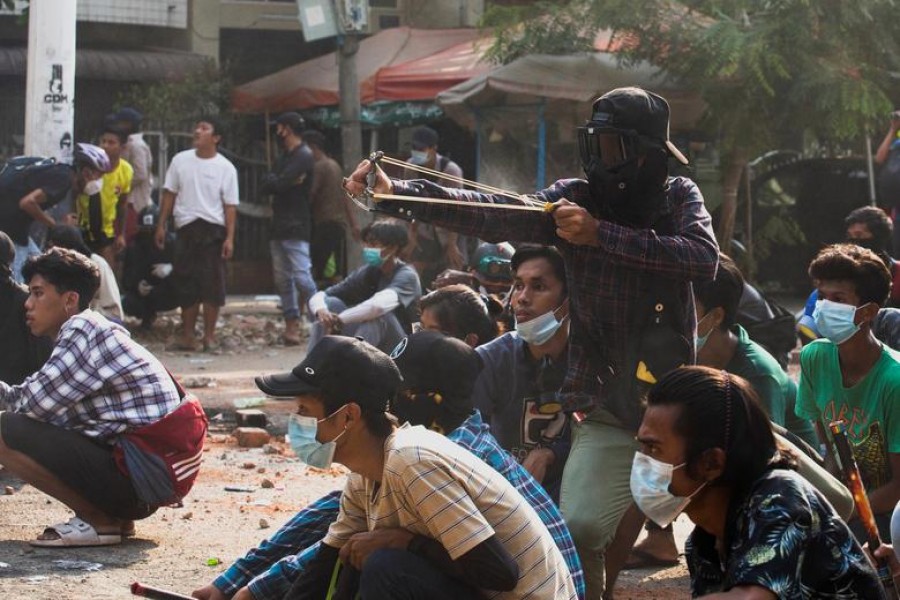 A man uses a slingshot during a protest against the military coup, in Yangon, Myanmar, March 28, 2021. REUTERS/Stringer