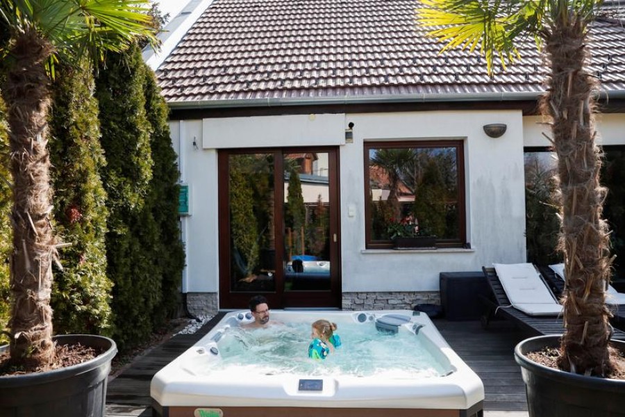 Gabor Kuntner enjoys the hot tub with his daughter, Linda in their garden, during the coronavirus disease (COVID-19) pandemic, in Budapest, Hungary, March 27, 2021. REUTERS/Bernadett Szabo